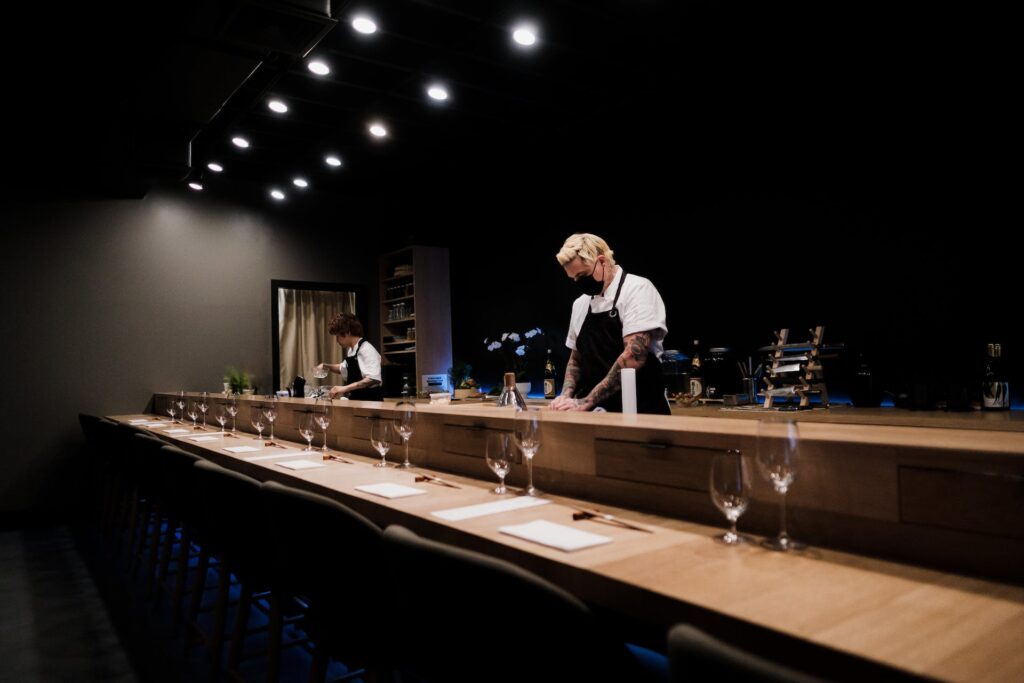 Man standing near the bar counter making sushi